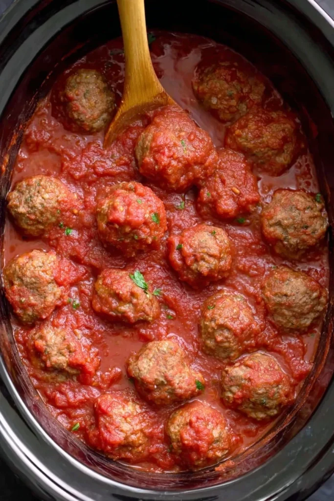 Juicy Italian meatballs simmering in marinara sauce inside a slow cooker